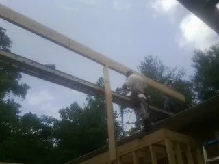 Carpenter setting a ridge beam over a new addition frame — Ice Dam Removal by Roofing Brothers in University Park