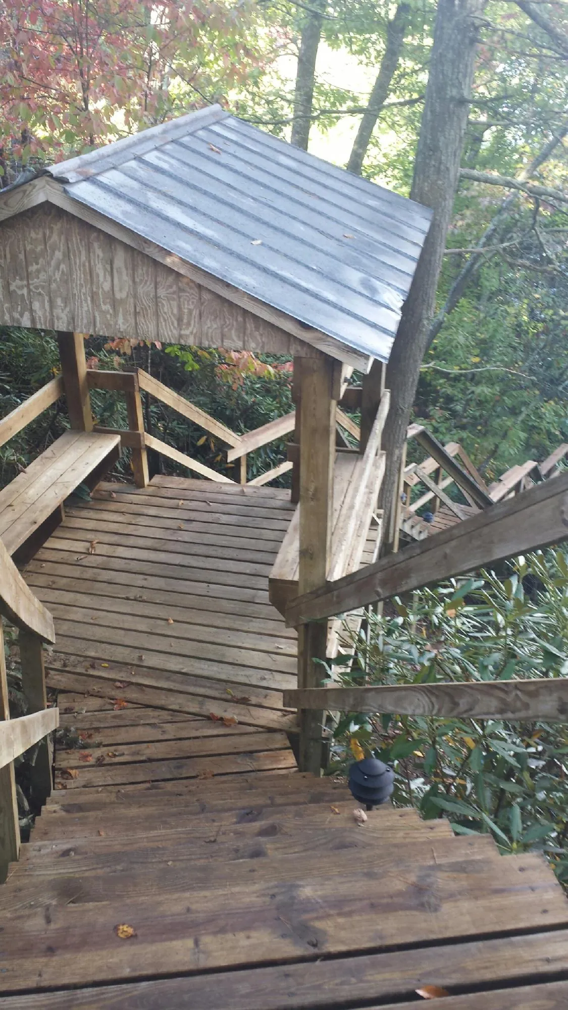 Metal roofed shelter over wooden steps on a wooded walkway — Skylight Repair & Installation work by our crew in University Park