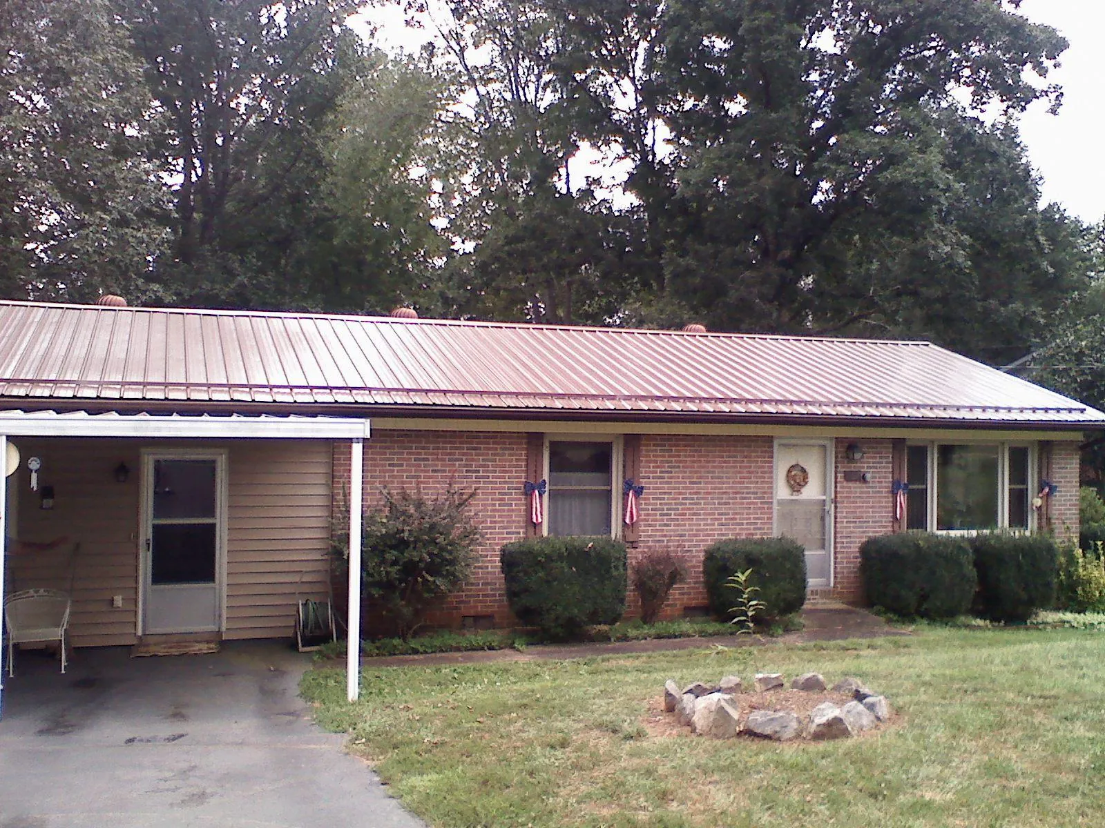 Bronze metal roof and carport on a brick ranch home — Roof Repair work by our crew in University Park
